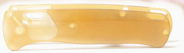 Loose amber translucent handle components with overlapping outlines, circular openings and a long end slot