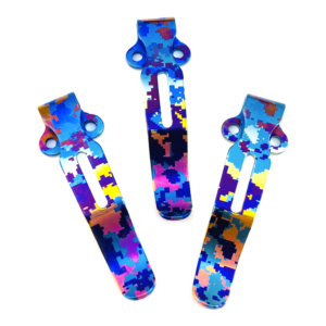 Three complete slotted pocket clips with the original blue, pink, gold-tone and dark pixel-like patterns and two lateral mounting ears